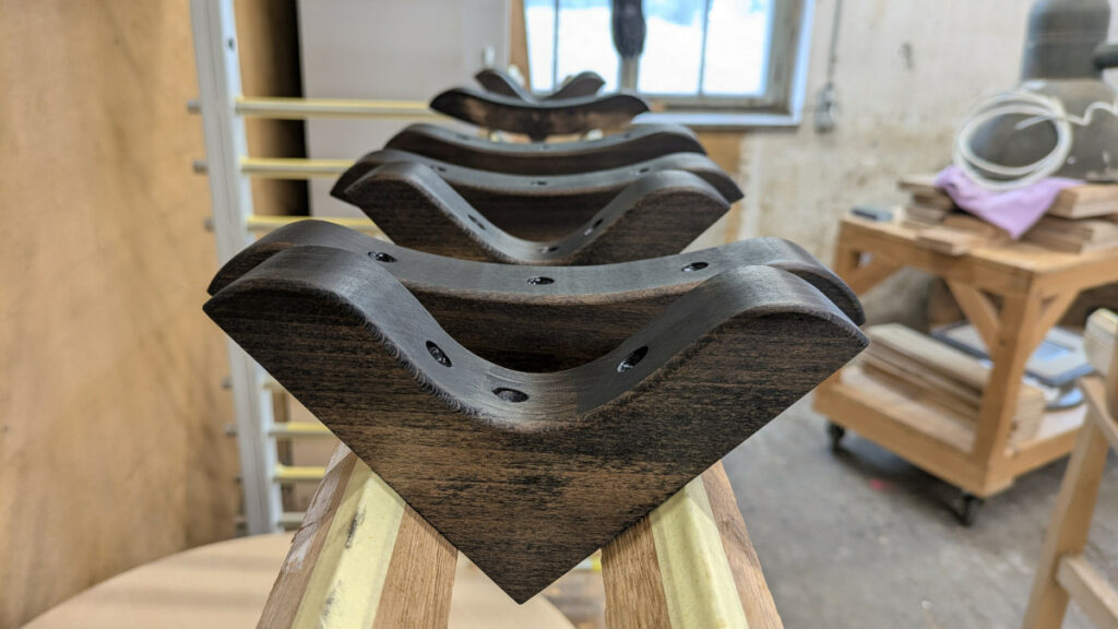 Verbindungsecken zur Stuhlverstaerkung Verbindungsecken aus Holz in einer Reihe, bereit zur Montage, um einen Stuhl zu verstärken.